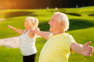 Senior couple doing light exercise outdoors